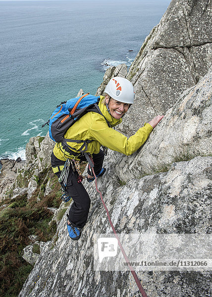 UK  Cornwall  lächelnde Frau beim Klettern auf dem Commando Ridge
