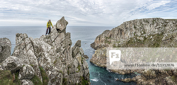 UK  Cornwall  woman on peak of Commando Ridge climbing route