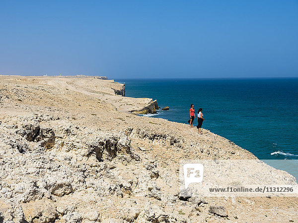 Oman  Ash Sharqiyah  Ad Daffah  zwei Frauen  die an der Klippe stehen.