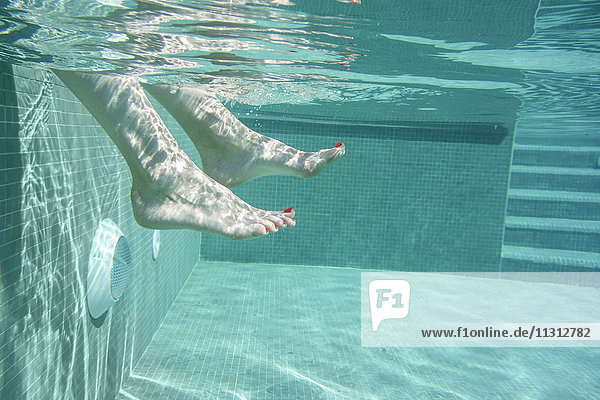 Weibliche Füße im Schwimmbad