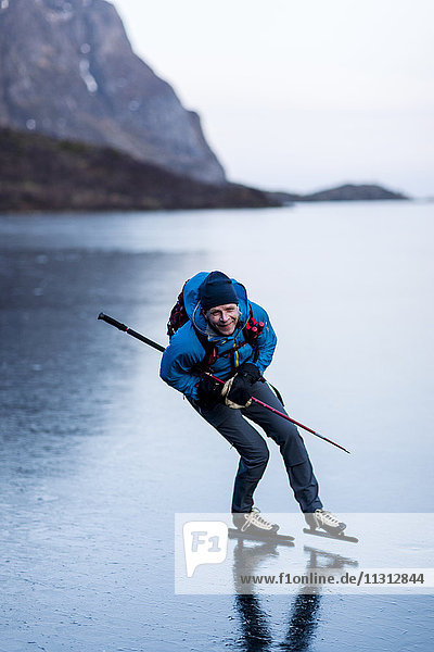 Porträt eines Mannes beim Schlittschuhlaufen auf einem zugefrorenen See