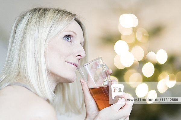Blonde Frau genießt ein Glas Tee