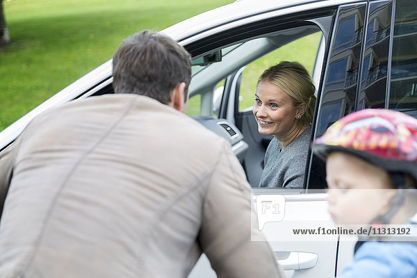 Mann spricht mit Frau  während sie Auto fährt