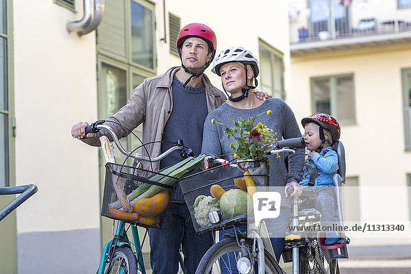 Mittleres erwachsenes Paar und Kind mit Fahrrädern