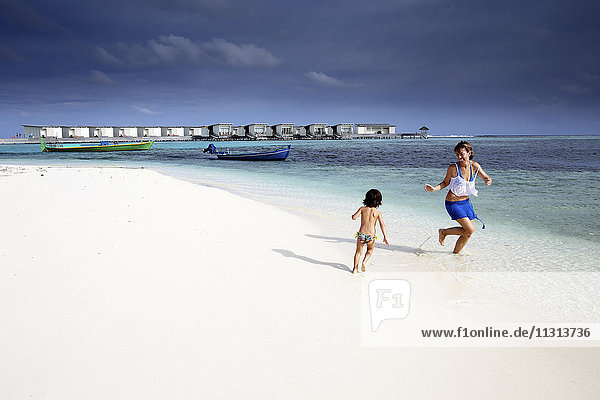 Malediven  Guraidhoo  Mutter und Tochter spielen am Strand
