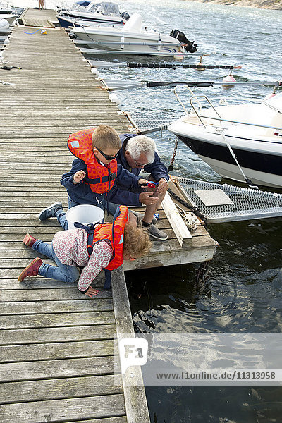 Großvater macht Boot mit Kindern fest