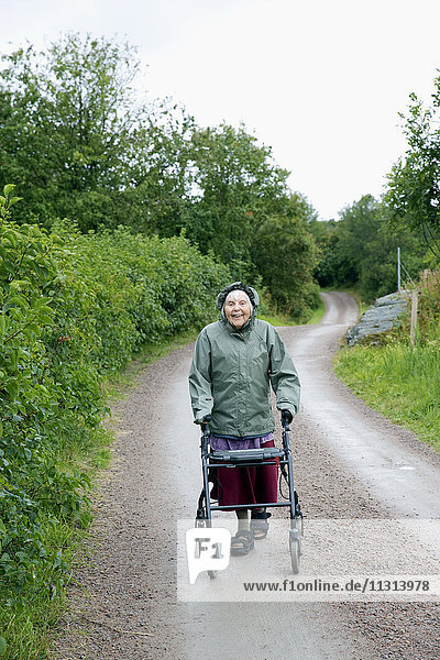 Ältere Frau geht auf Feldweg