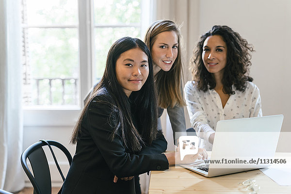 Drei Geschäftsfrauen arbeiten gemeinsam am Laptop