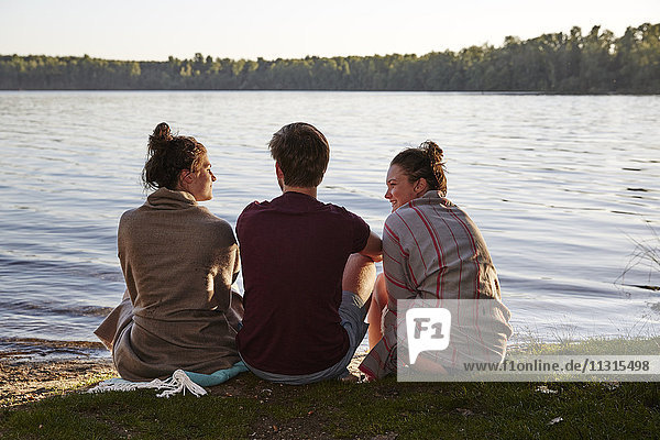 Friends sitting at a lake