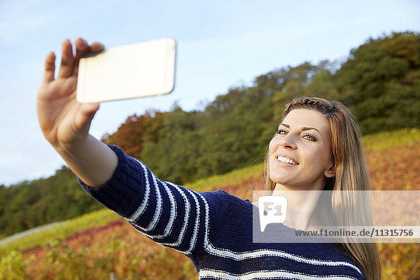 Young woman taking a selfie in a vineyard