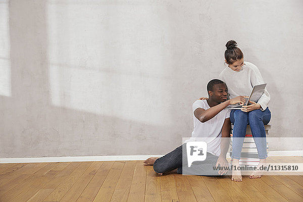 Junges Paar mit Laptop zu Hause