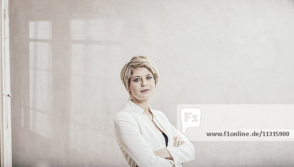 Porträt einer blonden Geschäftsfrau mit gekreuzten Armen