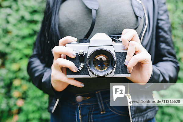 Woman's hands holding analogue camera  close-up
