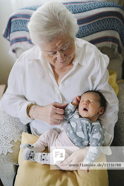 Urgroßmutter  die sich zu Hause um ihre Urenkelin kümmert.