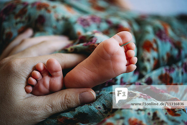 Mother's hand and baby's feet