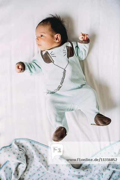 Newborn baby girl lying on bed