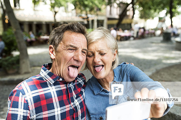 Senior Paar zieht lustige Gesichter  während sie Selfie mit dem Smartphone nehmen.