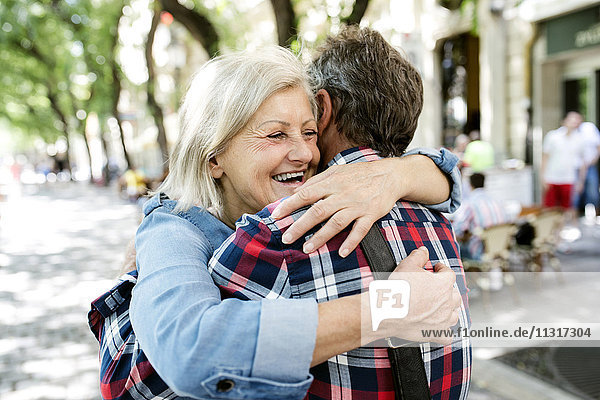 Glückliches Seniorenpaar  das sich auf der Straße umarmt.