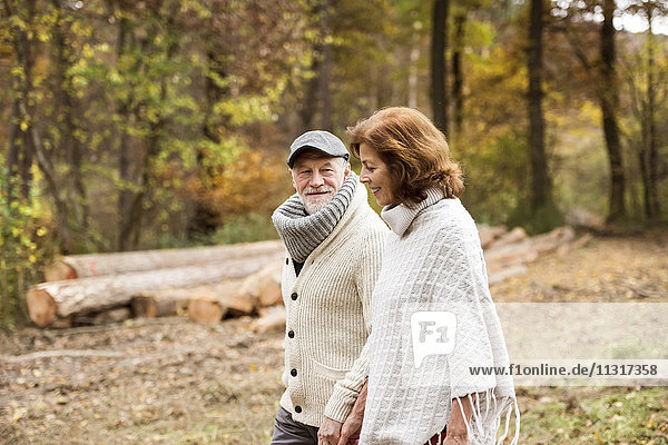 Seniorenpaar beim Waldspaziergang im Herbst