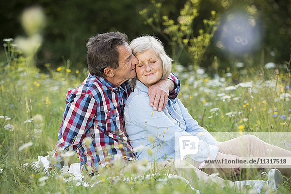 Seniorenpaar entspannt sich gemeinsam auf einer Wiese