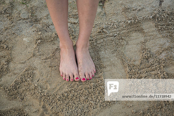 Frauenfüße auf Sand