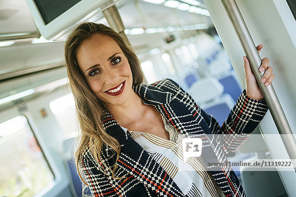 Porträt einer lächelnden Frau im Zug