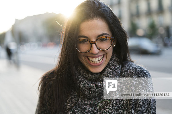 Porträt einer glücklichen jungen Frau mit Brille im Freien