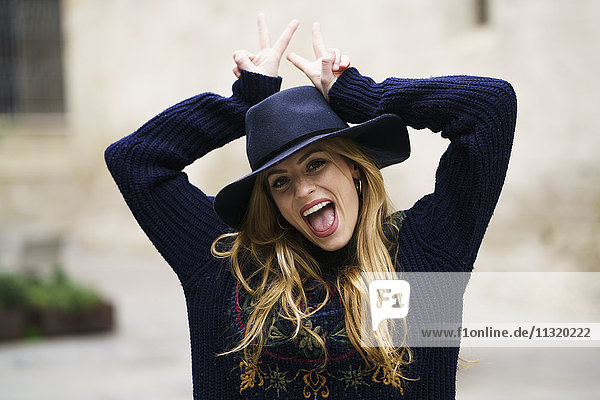 Porträt einer glücklichen jungen Frau mit blauem Hut