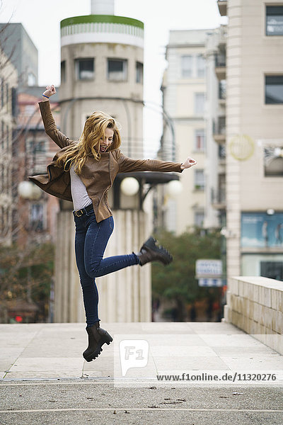 Excited young woman jumping in the air