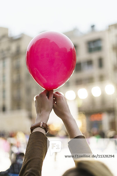Frauenhände mit rosa Luftballon