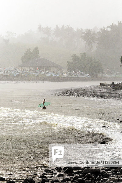 Indonesien  Bali  Surfer mit Surfbrettern im Meer