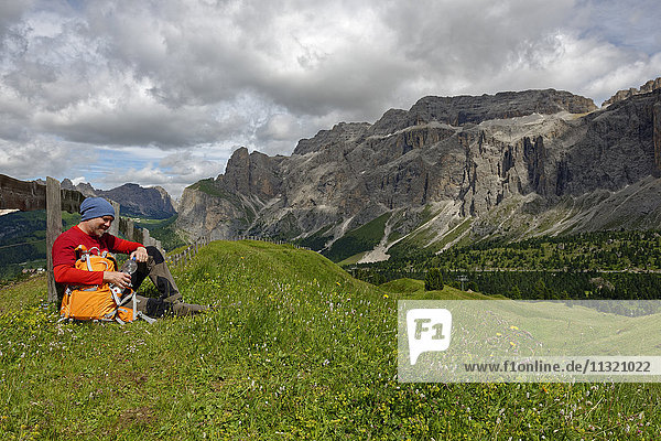 Italy  Alto Adige  Dolomites  Hiker resting on meadow at the Sella group