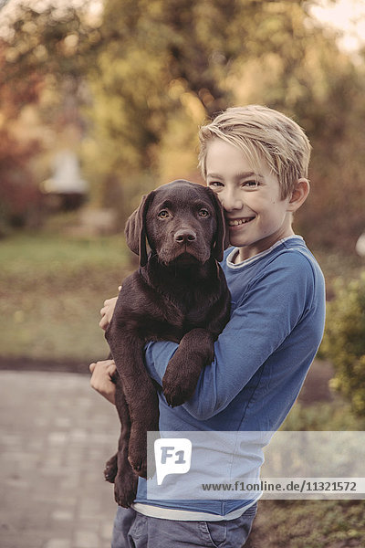 Boy holding Labrador Retriever