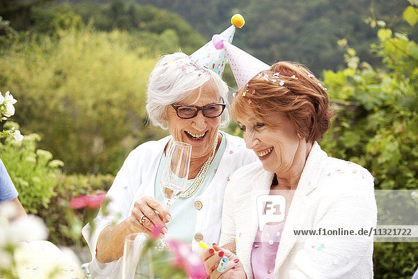 Seniorinnen trinken Champagner auf der Geburtstagsfeier