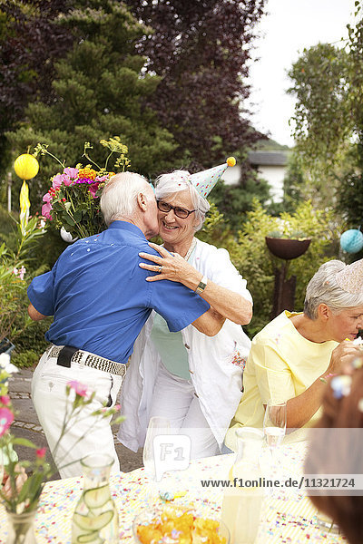 Senior Mann küsst ältere Dame bei Geburtstagsfeier