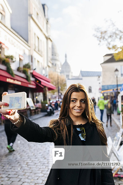 Frankreich  Paris  junge Frau  die einen Selfie in Montmartre nimmt.