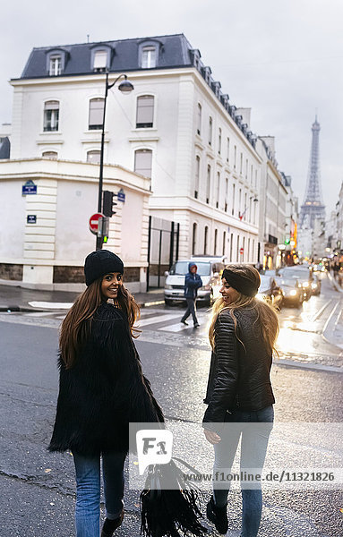 Frankreich,  Paris,  zwei junge Frauen auf der Straße mit dem Eiffelturm im Hintergrund