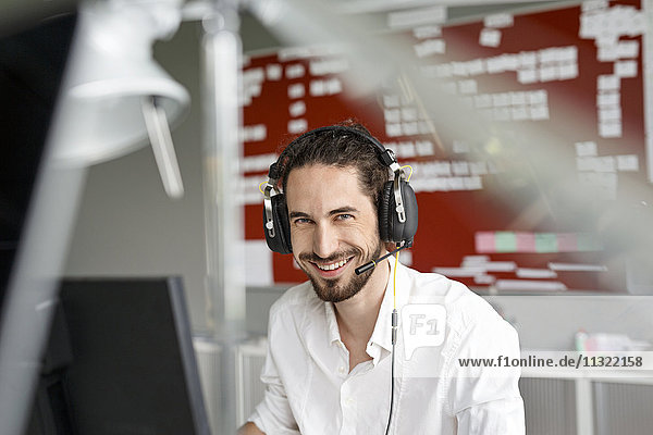 Smiling man in office with headset