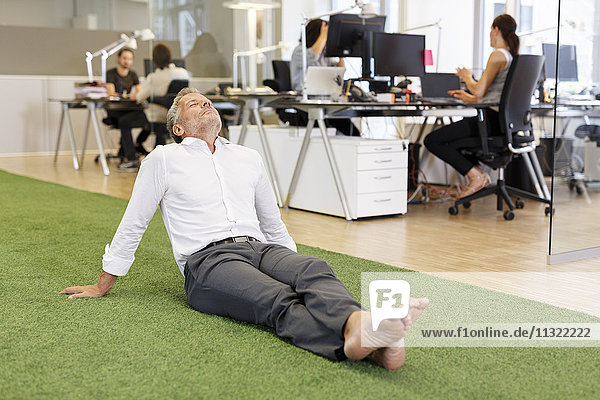 Businessman sitting on carpet in office