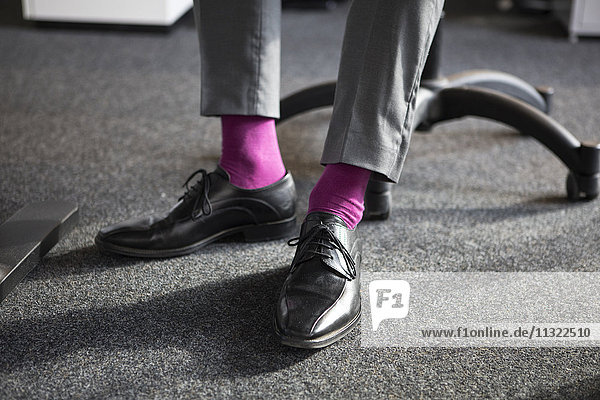 Nahaufnahme eines Geschäftsmannes im Büro in rosa Socken
