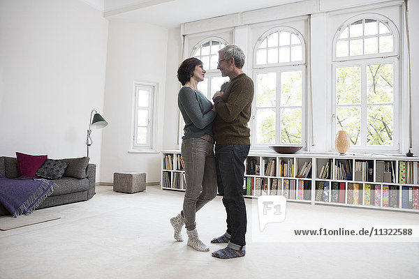 Mature couple standing in living room