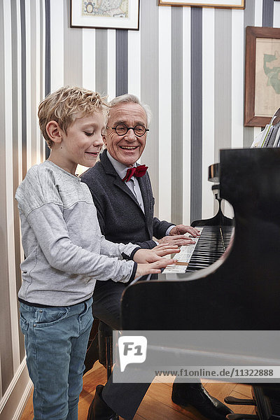 Großvater und Enkel beim gemeinsamen Klavierspielen