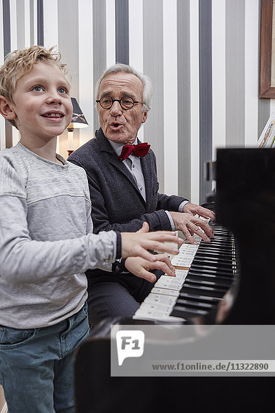 Grandfather and grandson playing piano and singing