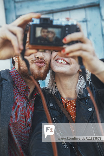 Junges Paar,  das einen Selfie mit Vintage-Kamera nimmt