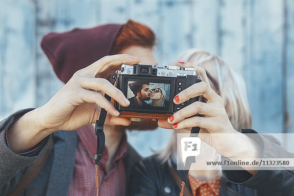 Young couple taking a selfie with vintage camera