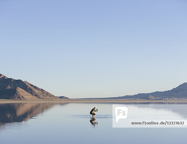Man walking on vast and flooded Bonneville Salt Flats  Utah