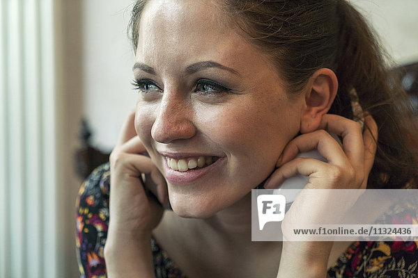 Smiling young woman holding headphones