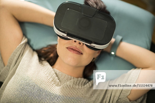 Junge Frau mit Virtual Reality Brille zu Hause