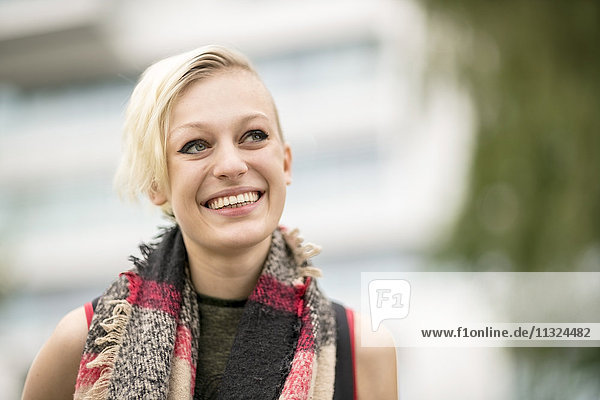 Porträt einer lächelnden blonden Frau mit Schal