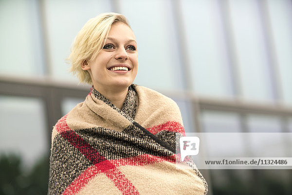 Portrait of smiling blonde woman wrapped in cloth